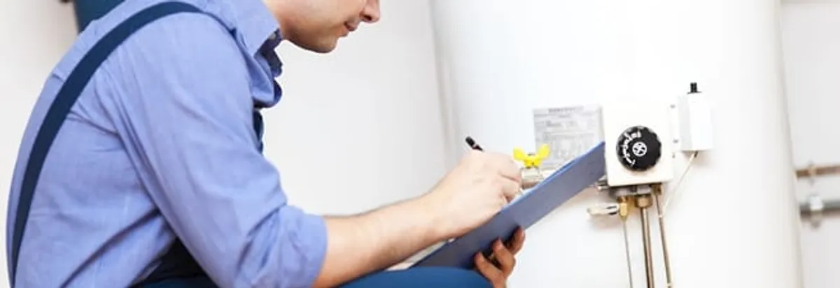 Water heater repair technician inspecting the unit and recording service notes in Baton Rouge, LA